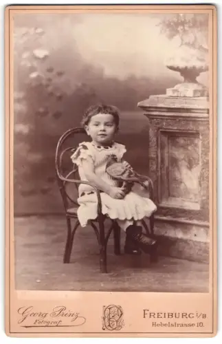 Fotografie Georg Prinz, Freiburg i. B., kleines Mädchen mit einer ausgestopften Taube auf dem Schoss, Taxidermie