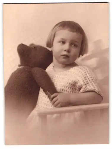 Fotografie niedliches kleines Mädchen kuschelt mit ihrem grossen Teddybär