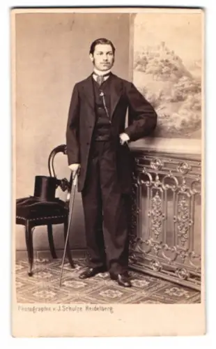 Fotografie J. Schulze, Heidelberg, junger Mann im dunklen Anzug nebst Zylinder und Flanierstock