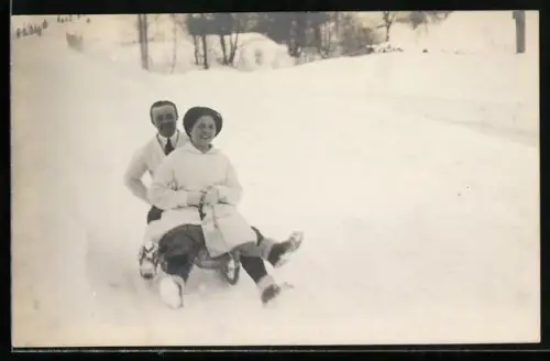 Foto-AK Paar auf einem Schlitten bei der Abfahrt