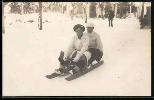Foto-AK Mann und Frau sitzen auf einem Schlitten