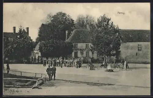 AK Pancy, Groupe de soldats sur la place du village devant des bâtiments anciens