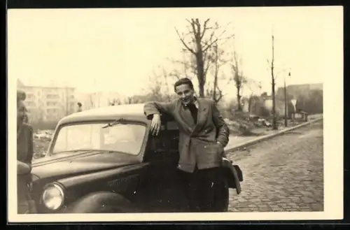 Foto-AK Opel Olympia, Mann lehnt an der Autotür