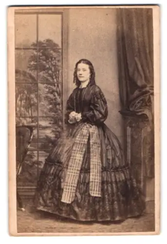 Fotografie Fred Jones, London, Oxford Street 146, Stehende Dame im viktorianischen Kleid mit Fenster