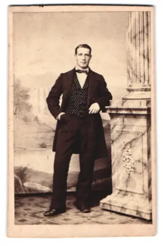 Fotografie unbekannter Fotograf und Ort, Mann in gepunkteter Weste an einer Säule