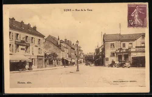 AK Lure, Rue de la Gare avec voitures et bâtiments anciens