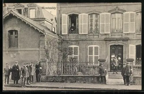 AK Montmédy, Scène de rue avec des habitants devant des maisons historiques
