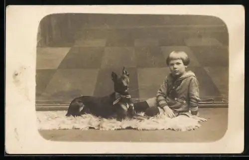 Foto-AK Kleines Kind mit Hund auf einem Fellteppich, 1921