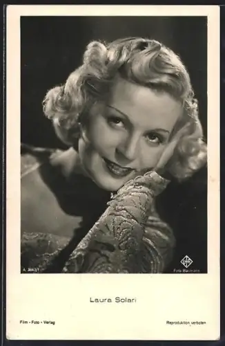 AK Schauspielerin Laura Solan mit der Hand den Kopf stützend und lächelnd