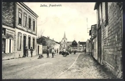 AK Selles, Rue animée avec des passants et vue sur l`église au loin