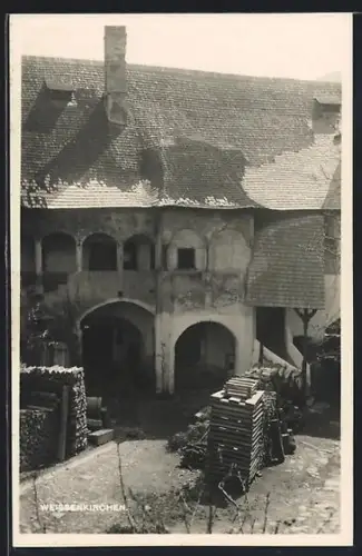AK Weissenkirchen, Hof mit gestapelten Holzscheiten
