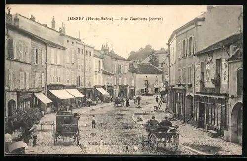 AK Jussey /Haute-Saône, Rue Gambetta, centre, avec calèches et piétons animant la scène