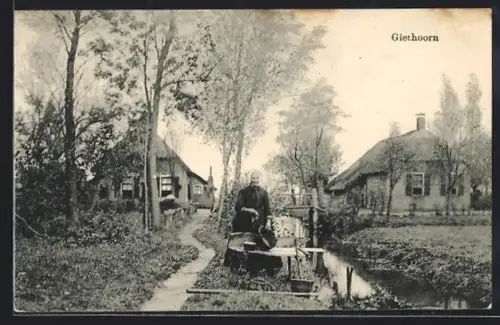 AK Giethoorn, Uferpartie mit Wäscherin in Tracht, Häuser