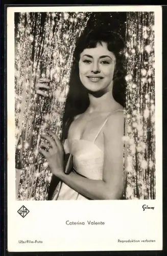 AK Schauspielerin Caterina Valente lächelnd durch Vorhang schauend