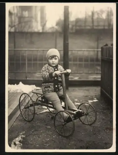 Fotografie kleines Kind zu Weihnachten auf Schmetzer Tretauto