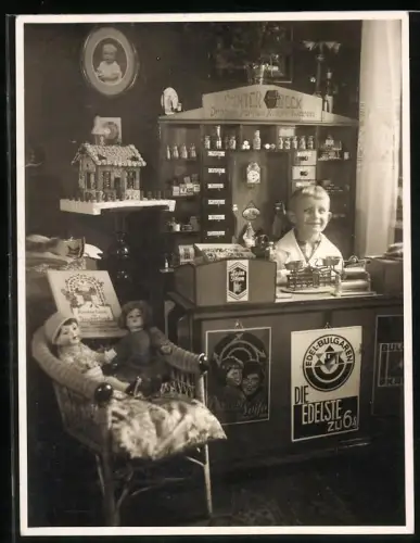 Fotografie junger Knabe in seinem Spielzeug Kaufmannsladen