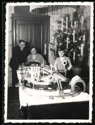 Fotografie kleiner Junge zu Weihnachten mit seiner Modelleisenbahn