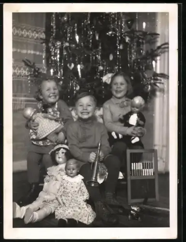 Fotografie drei kleine Kinder zu Weihnachten mit ihrem Puppen