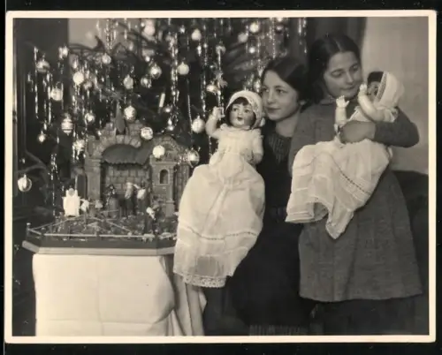 Fotografie zwei Mädchen zu Weihnachtne mit ihren Puppen im Arm, 1932
