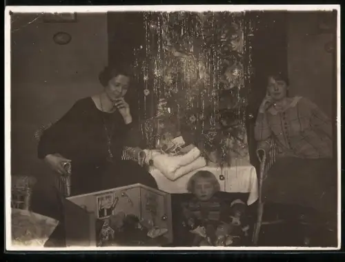 Fotografie kleines Kind zu Weihnachten mit ihrer Puppenstube und Puppen