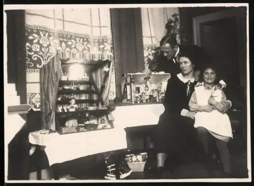 Fotografie Mädchen zu Weihnachten mit neuem Puppenhaus und Puppe im Arm