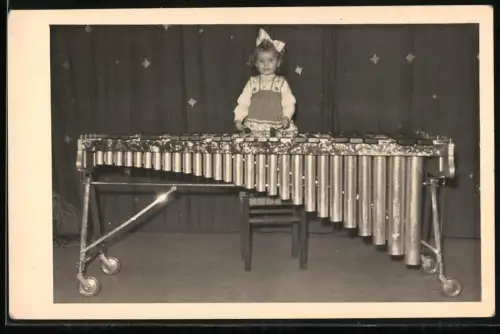 Fotografie kleines Mädchen spielt ein grosses Xylophon