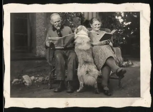 Fotografie Mann und Frau auf einer Bank, der Hund will sich dazwischen quetschen, 1930
