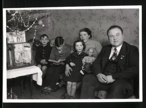 Fotografie Familie an Weihnachten mit Puppenstube und Weihnachtsbaum
