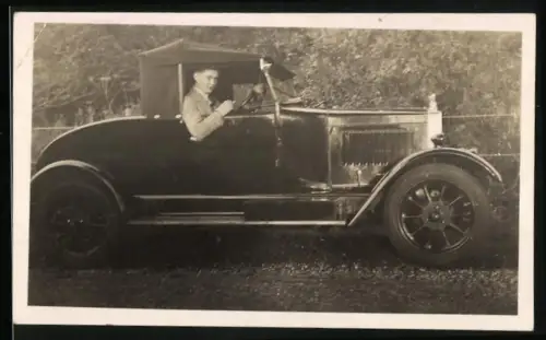 Fotografie junger Mann in seinem Auto Cabrio mit geschlossenem Verdeck