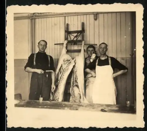 Fotografie Metzger / Fleischer mit zerteilten Schwein
