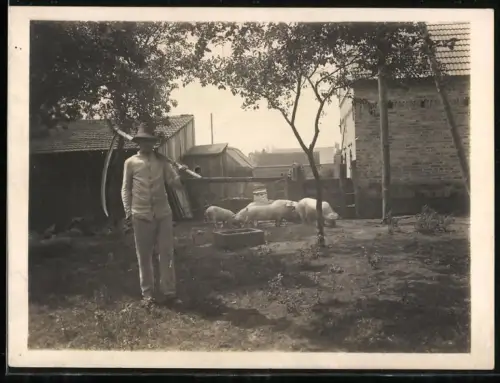 Fotografie junger Bauer mit Sende hütet die Schweine