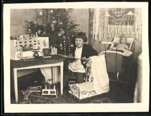 Fotografie Mädchen unterm Weihnachtsbaum mit Geschenken, Kaufmannsladen, Puppenwagen, Puppenbett