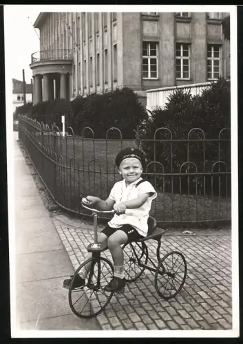 Fotografie junger Knabe auf seinem Dreirad mit Mütze Graf Zeppelin