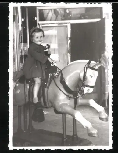 Fotografie Mädchen auf einem Pferde Karussell