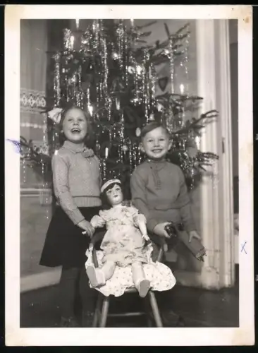 Fotografie Weihnachten, Kinder unterm Weihnachtsbaum mit grosser Puppe und Eisenbahn