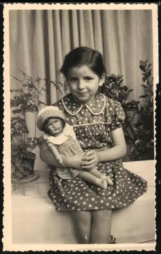 Fotografie junges Mädchen mit Puppe im Arm