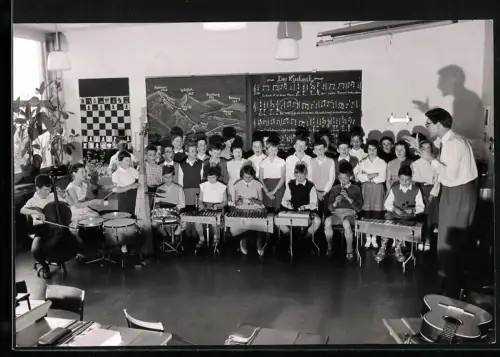 Fotografie E. Bachmann, Zürich, Musikschule, Kinder spielen Instrumente wie Trommel, Xylophon, Schachbrett an der Wand