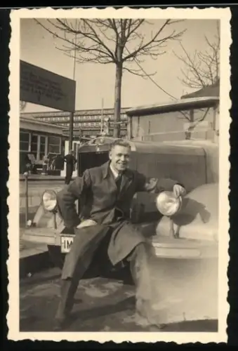 Fotografie junger Mann vor seinem Mercedes LKW
