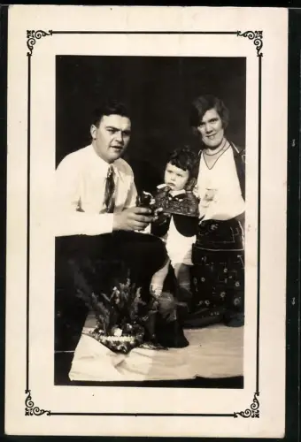 Fotografie Mutter und Vater schenken ihrem Kind Schoko Osterhasen zu Ostern