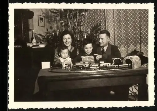 Fotografie Kinder freuen sich an Weihnachten über ihre Modelleisenbahn