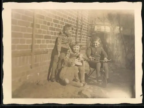 Fotografie kleine Kinder mit Teddybär und Dreirad