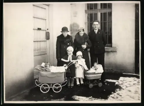 Fotografie Eltern mit ihrem Kindern samt Puppenwagen und Puppen
