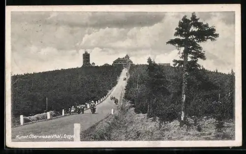 AK Oberwiesenthal i. Erzgeb., Blick aus dem Tal mit Landstrasse und Motorrädern