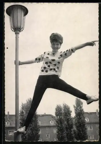 AK Musikerin Manuela steht auf Strassenlaterne