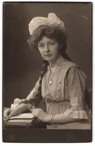 Fotografie Ferd. Urbahns, Kiel, junge Frau mit geflochtenem Zopf und Haarschleife