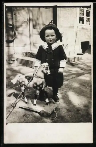 Foto-AK Kleines Kind mit Pferd auf Zugwagen, Schaukelpferd