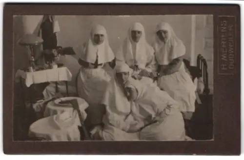 Fotografie H. Mertens, Dudweiler, Rot-Kreuz Krankenschwestern in ihrem Zimmer, Mann in der mitte hinten verkleidet