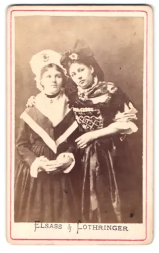 Fotografie unbekannter Fotograf und Ort, zwei junge Französinnen in Tracht aus Elsass und aus Lothringen
