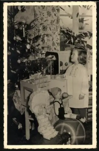Foto-AK Kleines Mädchen mit Puppe unterm Weihnachtsbaum