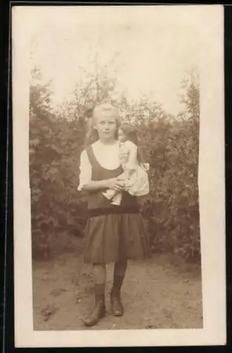Foto-AK Kleines Mädchen mit Puppe in einem Garten